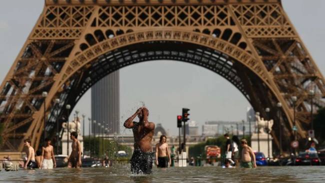 Foto Ilustrasi - Di Paris, ibu kota Prancis, para wisatawan yang berkunjung ke kota tersebut berusaha melindungi diri dari sinar matahari dengan menggunakan payung akibat gelombang panas ekstrem yang melanda Eropa (25/6/2026). (Foto: REUTERS/Abdul Saboor)