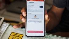 Penyedia layanan menunjukkan tampilan aplikasi registrasi kartu SIM baru dengan fitur verifikasi berbasis data biometrik wajah pada telepon seluler di sebuah gerai penjualan kartu perdana di Mampang Prapatan, Jakarta, Kamis (2/7/2026). (Foto: Antara/Salma Talita)