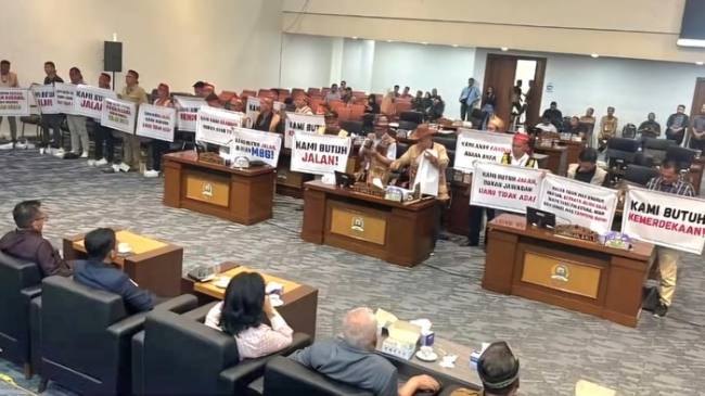 Warga Krayan bawa poster bernada tuntutan di ruangan DPRD Kaltara. (Foto: Istimewa)