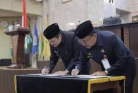 Wagub Hasnuryadi (kiri) menandatangani dokumen persetujuan raperda pertanggung jawaban APBD. Foto : Istimewa