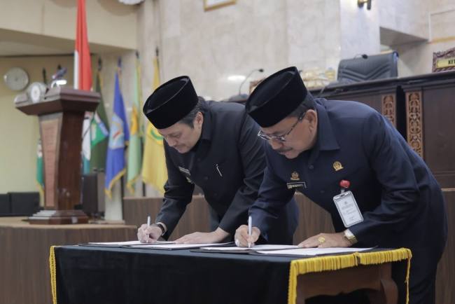 Wagub Hasnuryadi (kiri) menandatangani dokumen persetujuan raperda pertanggung jawaban APBD. Foto : Istimewa