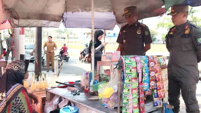 Pelaksana Tugas (Plt) Kepala Satuan Polisi Pamong Praja (Kasatpol PP) Kabupaten Balangan, Cecep Ruswantoro bersama jajaran saat memberikan edukasi dan pembinaan langsung kepada salah satu pedagang di kawasan Pasar Adaro.- Foto: MC Balangan