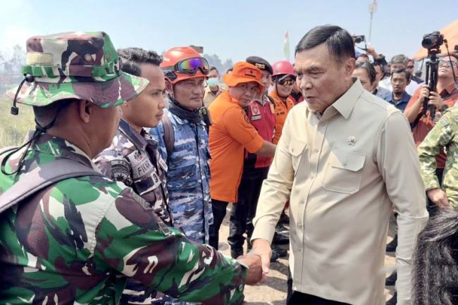 Menko Polkam Jenderal TNI (Purn) Djamari Chaniago (kanan) memberikan semangat kepada para petugas pada kunjungan kerja meninjau penanggulangan kebakaran hutan dan lahan (karhutla) di Banjarbaru, Kalimantan Selatan, Sabtu (1/8/2026). (Foto: Antara/Tumpal Andani A)