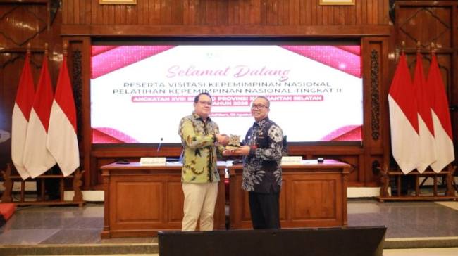 Sekda Kalsel (kiri) menyerahkan cinderamata kenang-kenangan kepada perwakilan Jawa Timur. Foto : istimewa