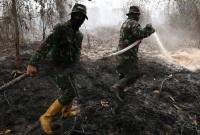 Personel Yonif TP 882/Hulubalang melakukan pembasahan untuk mencegah api kembali menyala di lokasi kebakaran lahan gambut di Desa Arang Limbung, Kecamatan Sungai Raya, Kabupaten Kubu Raya, Kalimantan Barat, Minggu (23/8/2026). (Foto: Antara/Jessica Wuysang)