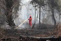 Personel Manggala Agni Daops Kalimantan VIII/Pontianak melakukan pembasahan untuk mencegah api kembali menyala di lahan gambut yang terbakar di Sekunder C, Rasau Jaya 3, Kabupaten Kubu Raya, Kalimantan Barat, Kamis (27/8/2026). (Foto: Antara/Jessica Wuysang)