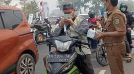 Dinkes Palangka Raya membagikan masker bagi pengguna jalan menyusul kabut asap karhutla yang semakin pekat. (Foto: HO-Dinkes Palangka Raya)
