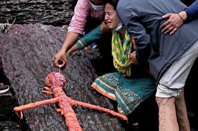Warga menangis saat mengikuti upacara pemakaman simbolis untuk kerabat mereka yang hilang karena banjir bandang di Kuil Pashupatinath, Kathmandu, Nepal, Rabu (2/9/2026). (Foto: AFP/Prakash Mathema)
