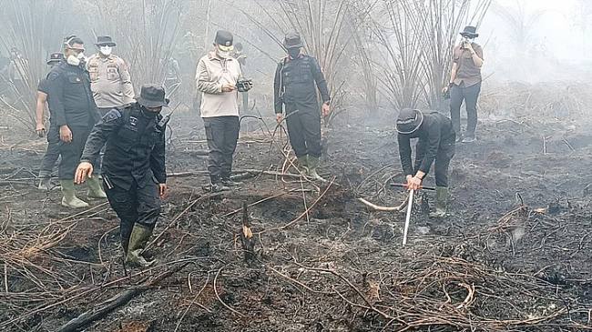 Petugas suntikan cairan tepung di lahan gambut yang terbakar. (Foto: HO-Polda Kalteng)