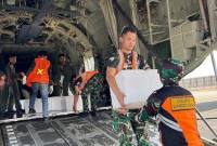 
Personel Lanud Sjamsudin Noor menurunkan dry ice yang dibawa Pesawat TNI AU. (Foto: HO-Antara)