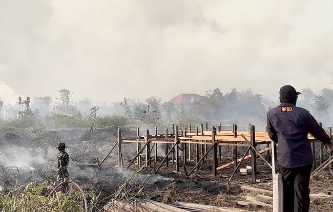 TIM gabungan penanggulangan kebakaran hutan dan lahan (karhutla) melakukan pendinginan di lahan bekas terbakar yang berada di dekat permukiman warga di Kabupaten Kutai Timur, Kalimantan Timur. (Foto: Antara/M Hafif Nikolas)
