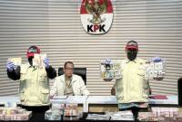 Pelaksana Tugas Direktur Penyidikan Komisi Pemberantasan Korupsi (KPK) Achmad Taufik Husein (tengah) mempersilakan dua pegawai KPK memperlihatkan barang bukti kasus dugaan korupsi penggunaan dana siap pakai Badan Nasional Penanggulangan Bencana (BNPB) di Gedung Merah Putih KPK, Jakarta, Jumat (16/10/2026). (Foto: Antara/Rio Feisal)
