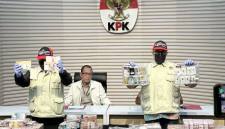 Pelaksana Tugas Direktur Penyidikan Komisi Pemberantasan Korupsi (KPK) Achmad Taufik Husein (tengah) mempersilakan dua pegawai KPK memperlihatkan barang bukti kasus dugaan korupsi penggunaan dana siap pakai Badan Nasional Penanggulangan Bencana (BNPB) di Gedung Merah Putih KPK, Jakarta, Jumat (16/10/2026). (Foto: Antara/Rio Feisal)