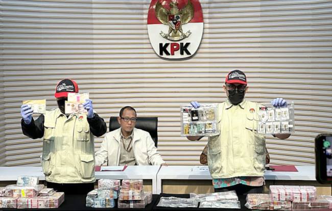 Pelaksana Tugas Direktur Penyidikan Komisi Pemberantasan Korupsi (KPK) Achmad Taufik Husein (tengah) mempersilakan dua pegawai KPK memperlihatkan barang bukti kasus dugaan korupsi penggunaan dana siap pakai Badan Nasional Penanggulangan Bencana (BNPB) di Gedung Merah Putih KPK, Jakarta, Jumat (16/10/2026). (Foto: Antara/Rio Feisal)
